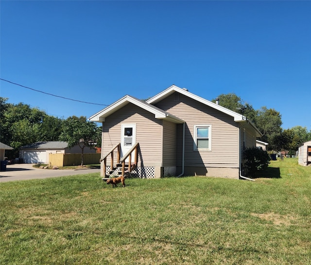 view of home's exterior with a yard, an outdoor structure, and a garage