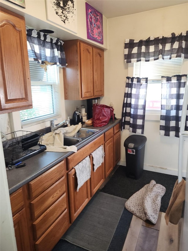 kitchen featuring a sink, brown cabinetry, and dark countertops