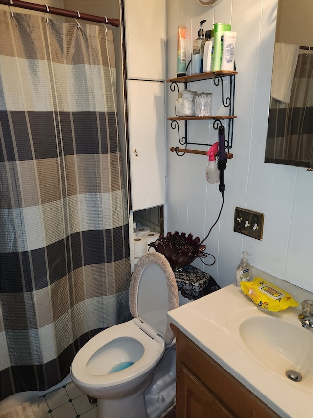 bathroom with tile patterned flooring, vanity, toilet, and a shower with curtain