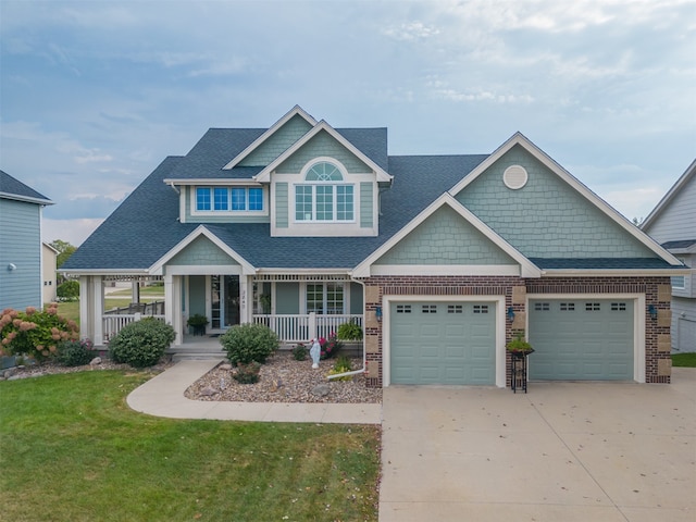 craftsman-style home featuring covered porch, a front yard, and a garage