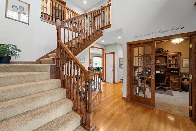 stairway featuring a high ceiling and hardwood / wood-style flooring