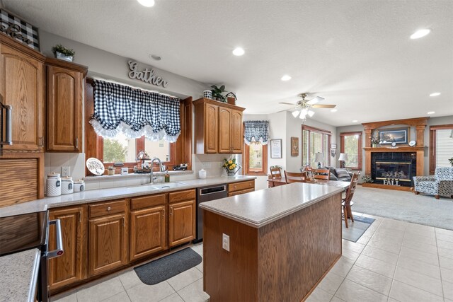 kitchen featuring a healthy amount of sunlight, dishwasher, a large fireplace, and ceiling fan