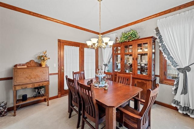 dining area featuring light carpet, an inviting chandelier, and plenty of natural light