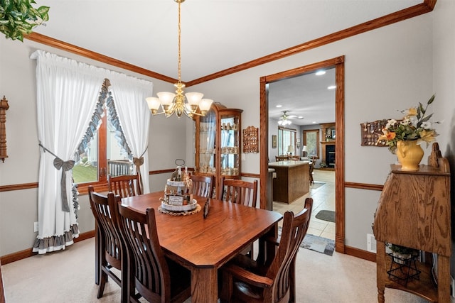 carpeted dining space featuring ceiling fan with notable chandelier and ornamental molding