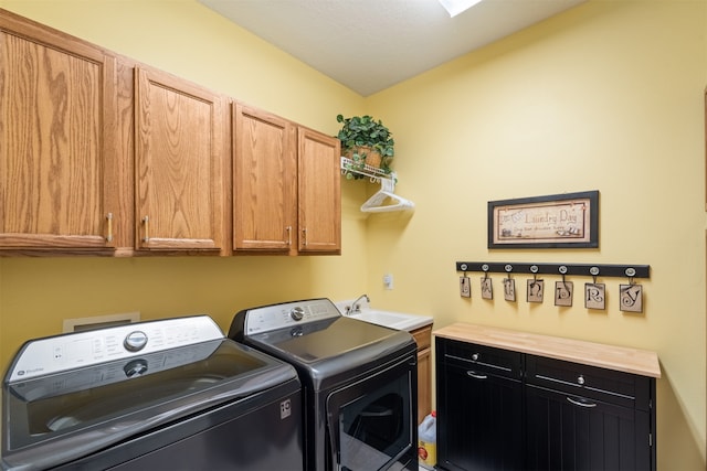 laundry room featuring cabinets, washer and dryer, and sink