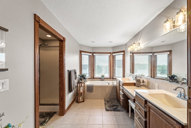 bathroom featuring vanity, separate shower and tub, a textured ceiling, and tile patterned floors