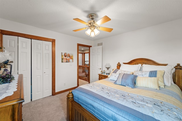 bedroom featuring a textured ceiling, ceiling fan, light colored carpet, and a closet