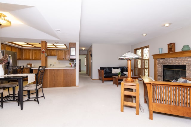 living room with a brick fireplace and light carpet