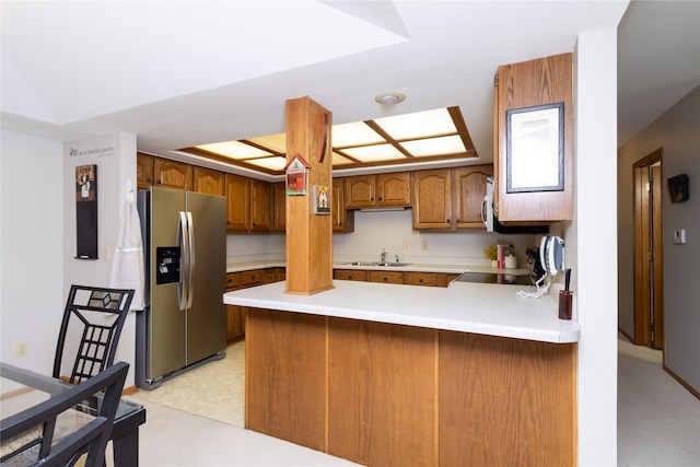 kitchen featuring kitchen peninsula, stainless steel fridge with ice dispenser, and sink