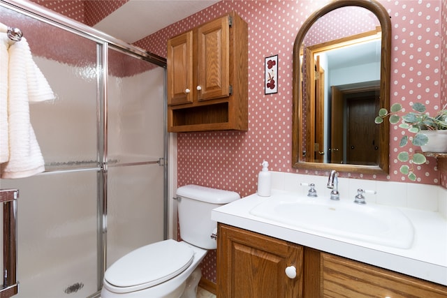 bathroom featuring walk in shower, vanity, and toilet