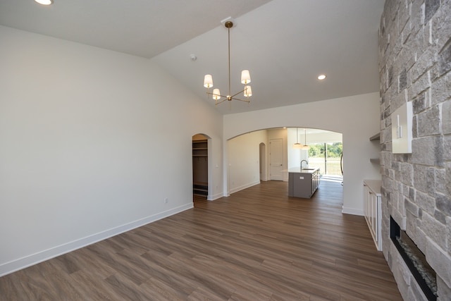 unfurnished living room featuring a fireplace, dark hardwood / wood-style flooring, a chandelier, and sink