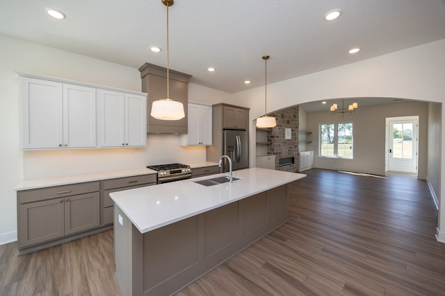 kitchen featuring stainless steel appliances, decorative light fixtures, gray cabinets, and sink