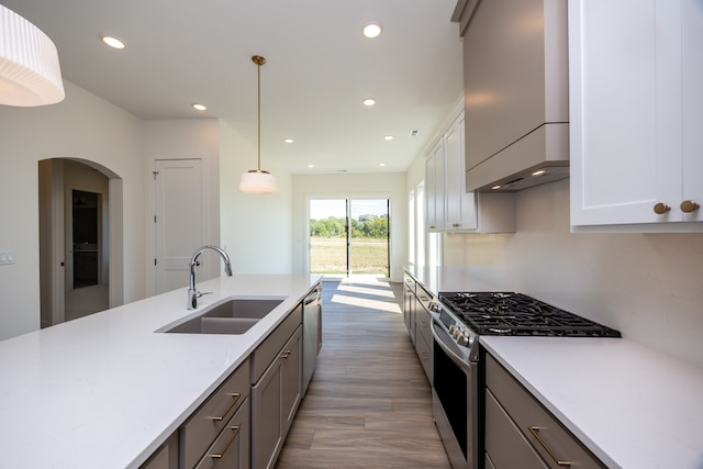 kitchen with stainless steel appliances, sink, pendant lighting, and white cabinets