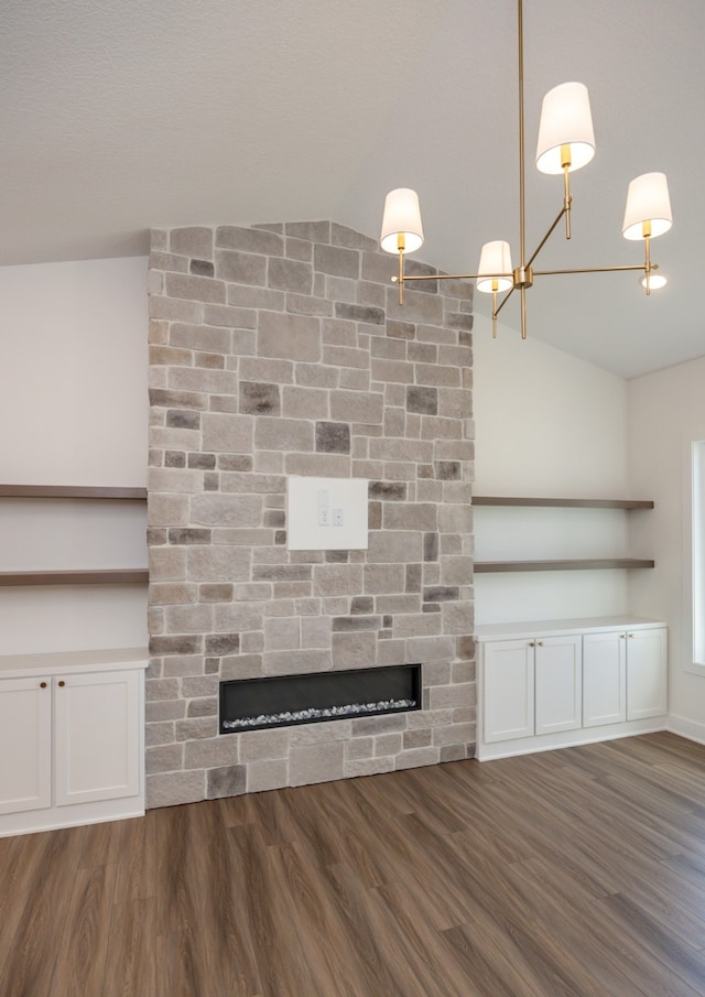 unfurnished living room with dark hardwood / wood-style flooring, a stone fireplace, and vaulted ceiling