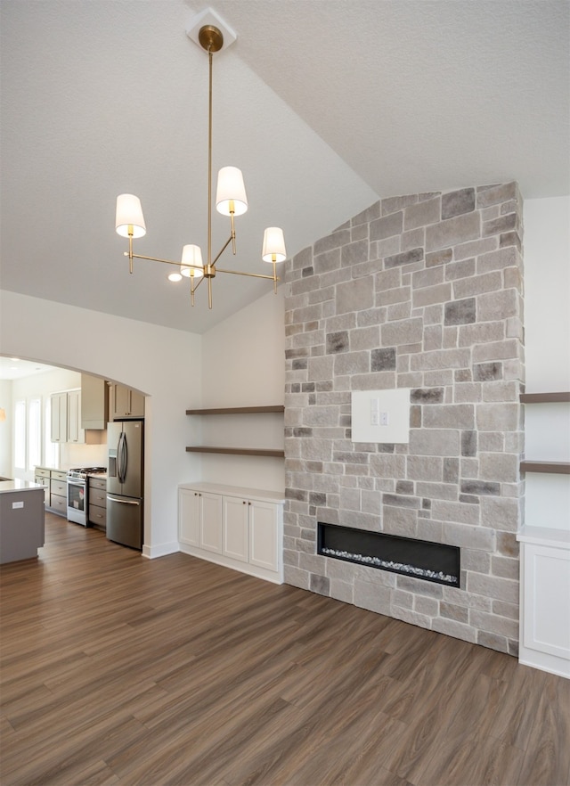 unfurnished living room featuring dark hardwood / wood-style flooring, a fireplace, a chandelier, and vaulted ceiling