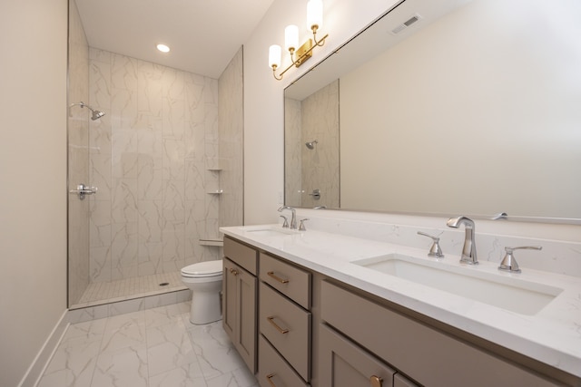 bathroom featuring vanity, toilet, and tiled shower