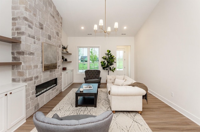 living room with an inviting chandelier, baseboards, recessed lighting, a large fireplace, and light wood finished floors