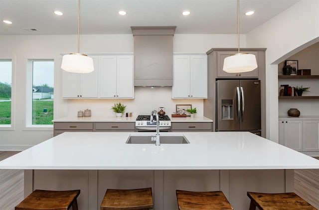 kitchen with a sink, hanging light fixtures, a breakfast bar, and stainless steel appliances