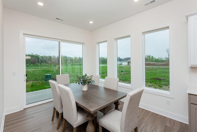dining area with visible vents, a healthy amount of sunlight, and light wood-type flooring