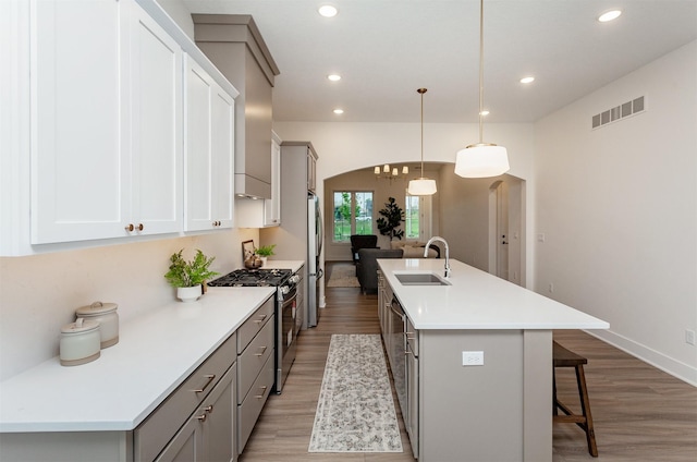 kitchen featuring appliances with stainless steel finishes, a sink, visible vents, and light wood-type flooring