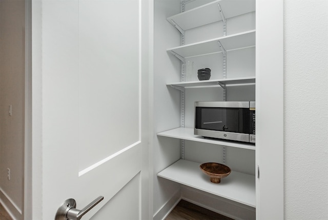 details with baseboards and stainless steel microwave