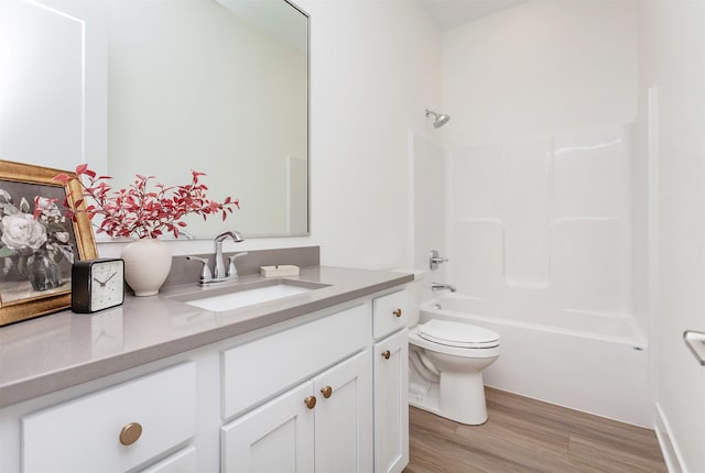 bathroom with toilet,  shower combination, wood finished floors, and vanity