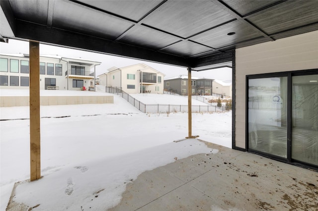 snow covered patio with fence and a residential view