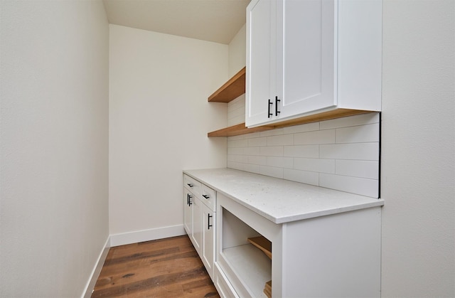 unfurnished office featuring dark wood-style flooring and baseboards