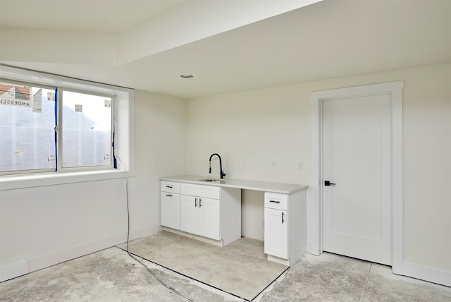 laundry room with a sink and baseboards