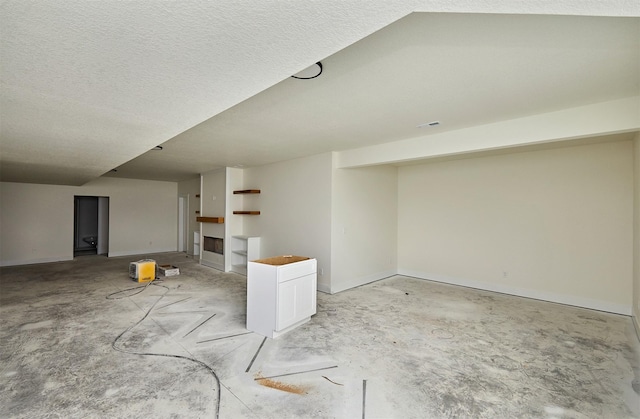 finished basement with baseboards and a textured ceiling