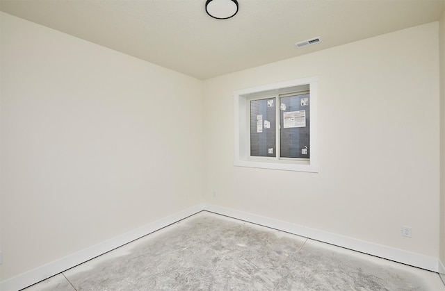 spare room featuring visible vents, unfinished concrete flooring, and baseboards