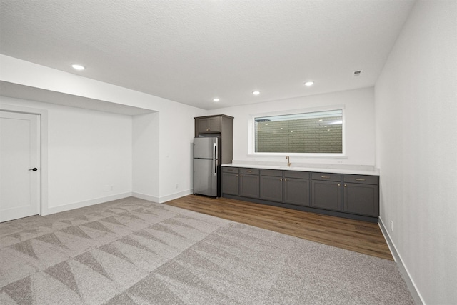 interior space with light carpet, a textured ceiling, and sink