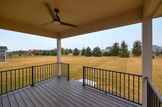 wooden deck featuring ceiling fan and a yard