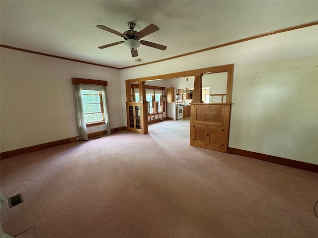 empty room with ornamental molding, ceiling fan, and light colored carpet