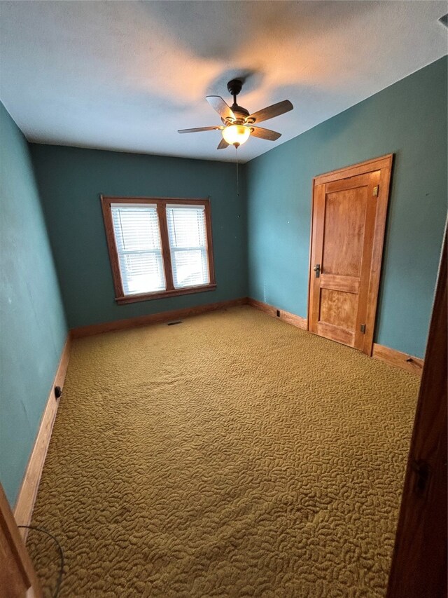 spare room with a textured ceiling, carpet, and ceiling fan