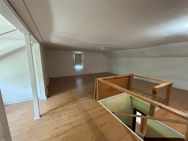 hall featuring lofted ceiling and hardwood / wood-style flooring