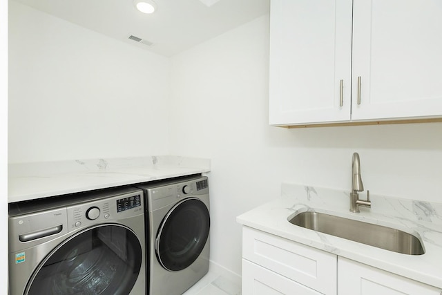 laundry area with sink, light tile patterned floors, cabinets, and independent washer and dryer