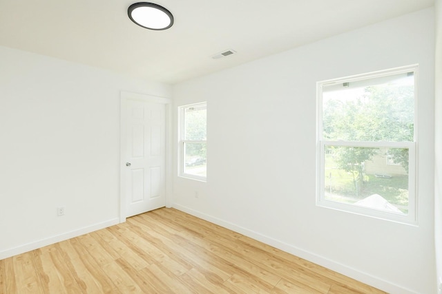 spare room with a healthy amount of sunlight and light hardwood / wood-style flooring