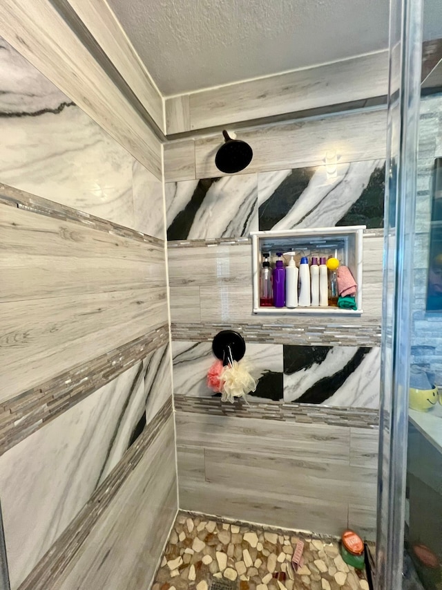 bathroom featuring a textured ceiling and a shower