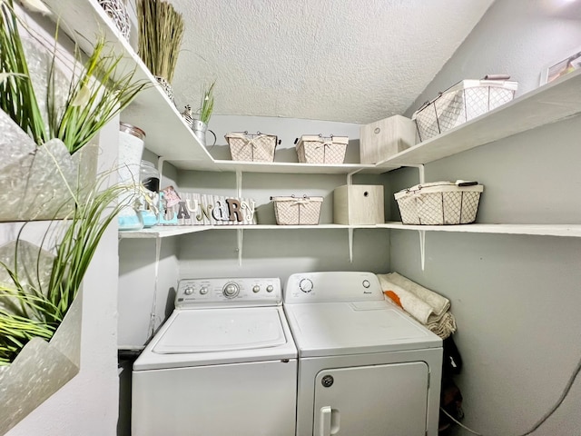 clothes washing area with a textured ceiling and washer and dryer