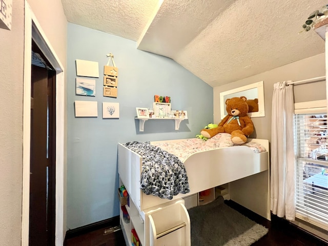 bedroom with a textured ceiling and vaulted ceiling