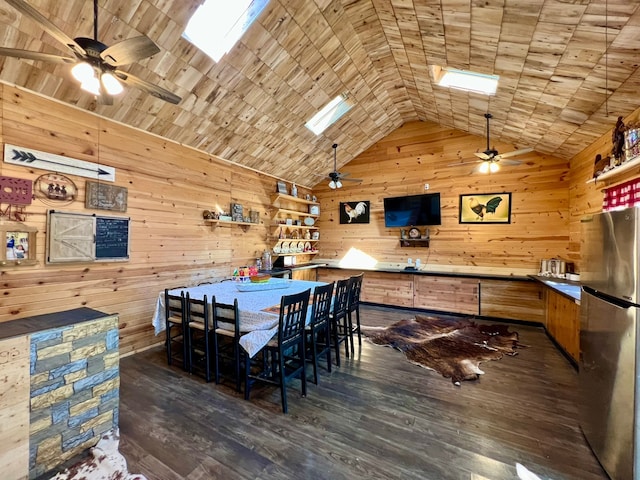 dining room with ceiling fan, wood walls, and dark hardwood / wood-style floors