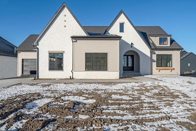 snow covered house featuring a garage