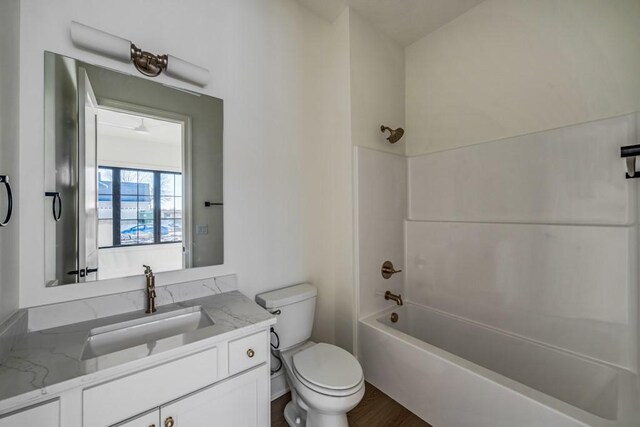 full bathroom with toilet, bathing tub / shower combination, wood-type flooring, and vanity