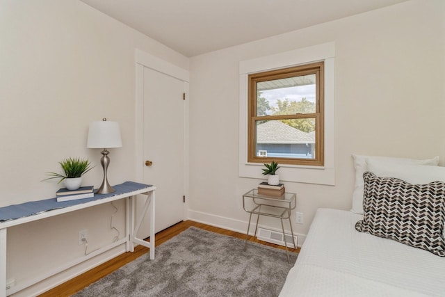 bedroom featuring baseboards, wood finished floors, and visible vents