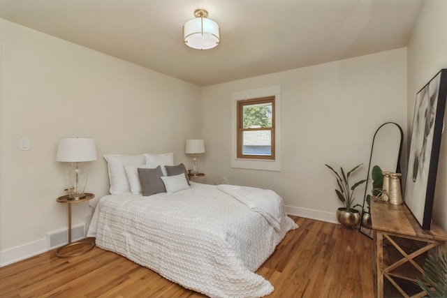 bedroom with baseboards, visible vents, and light wood-style floors