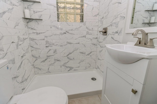 bathroom with toilet, vanity, a stall shower, and tile patterned floors