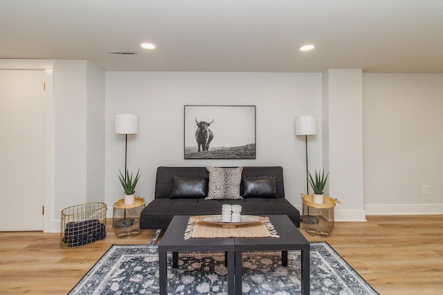 living room featuring visible vents, baseboards, wood finished floors, and recessed lighting
