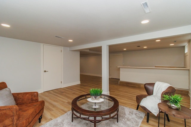 living room featuring recessed lighting, light wood-style flooring, and visible vents