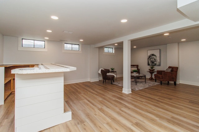 interior space featuring light stone countertops, light hardwood / wood-style flooring, and white cabinets